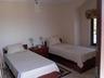 Twin bedroom with french doors opening onto sea view balacon